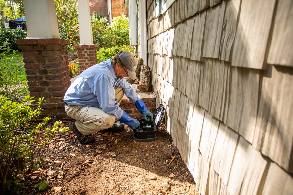 pest control technician crew inspects perimeter of home