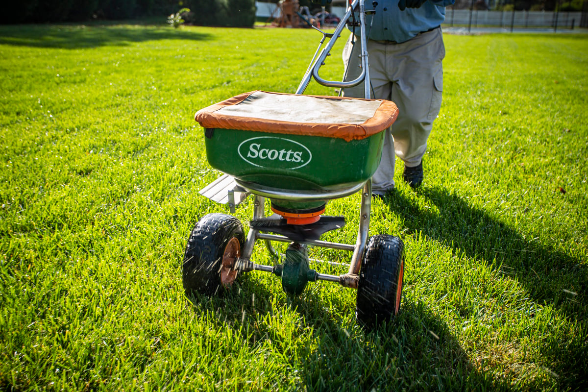 lawn care team fertilizing grass