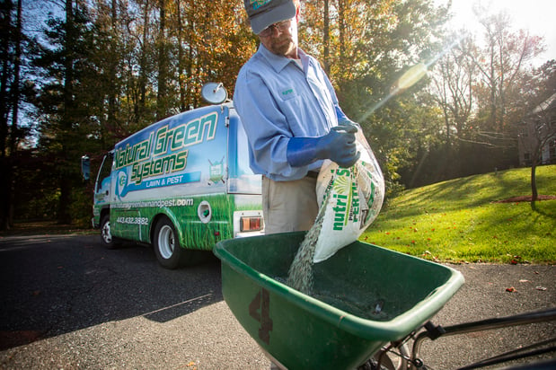 lawn technician applying fertilizer in Maryland