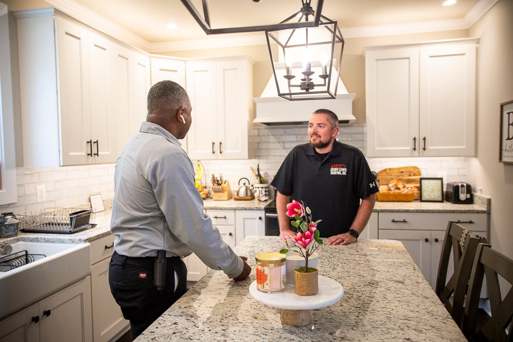 homeowner meets with pest control expert in kitchen