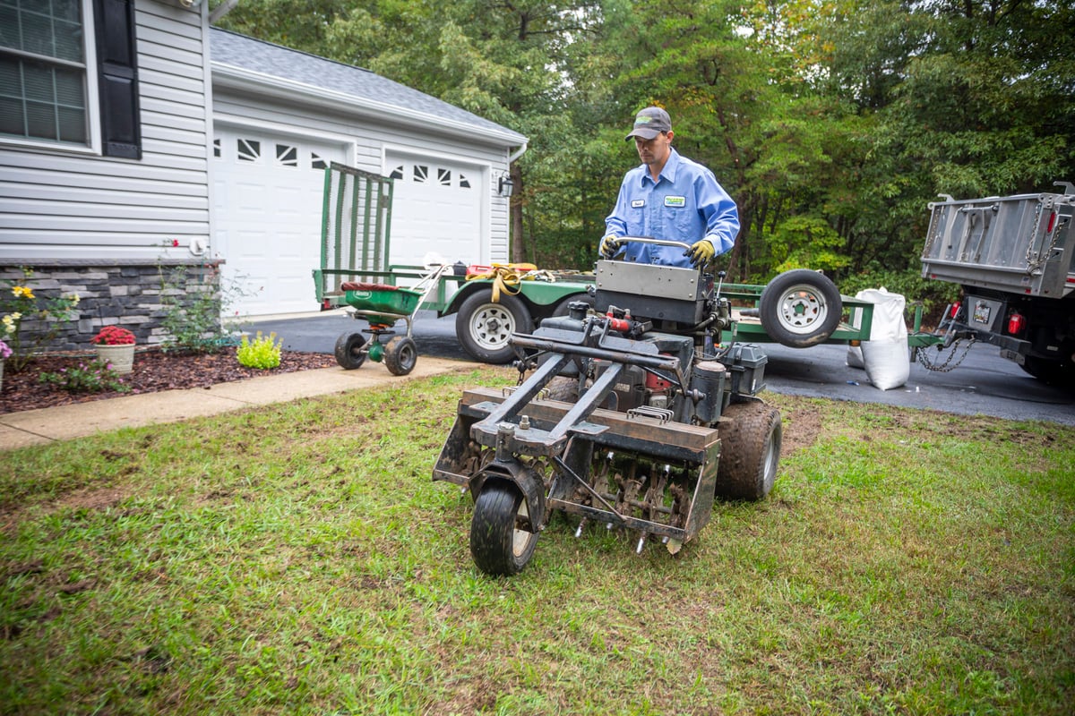 lawn care team operates lawn aeration machine 