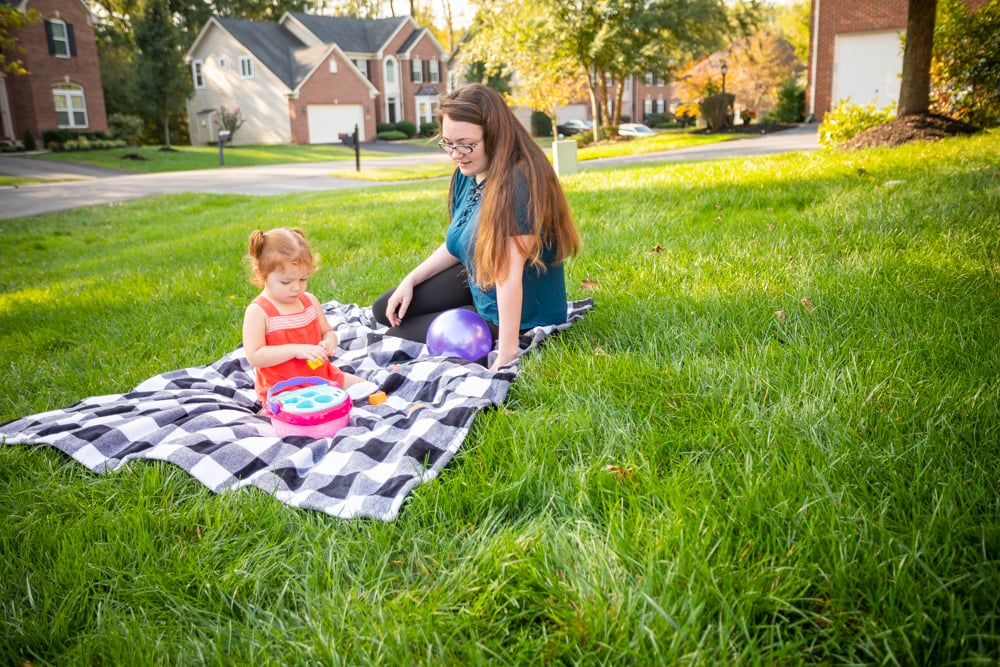 customer sits on healthy green grass with child
