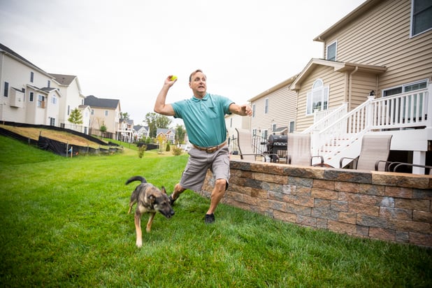 Man playing with dog in yard with no fleas or ticks