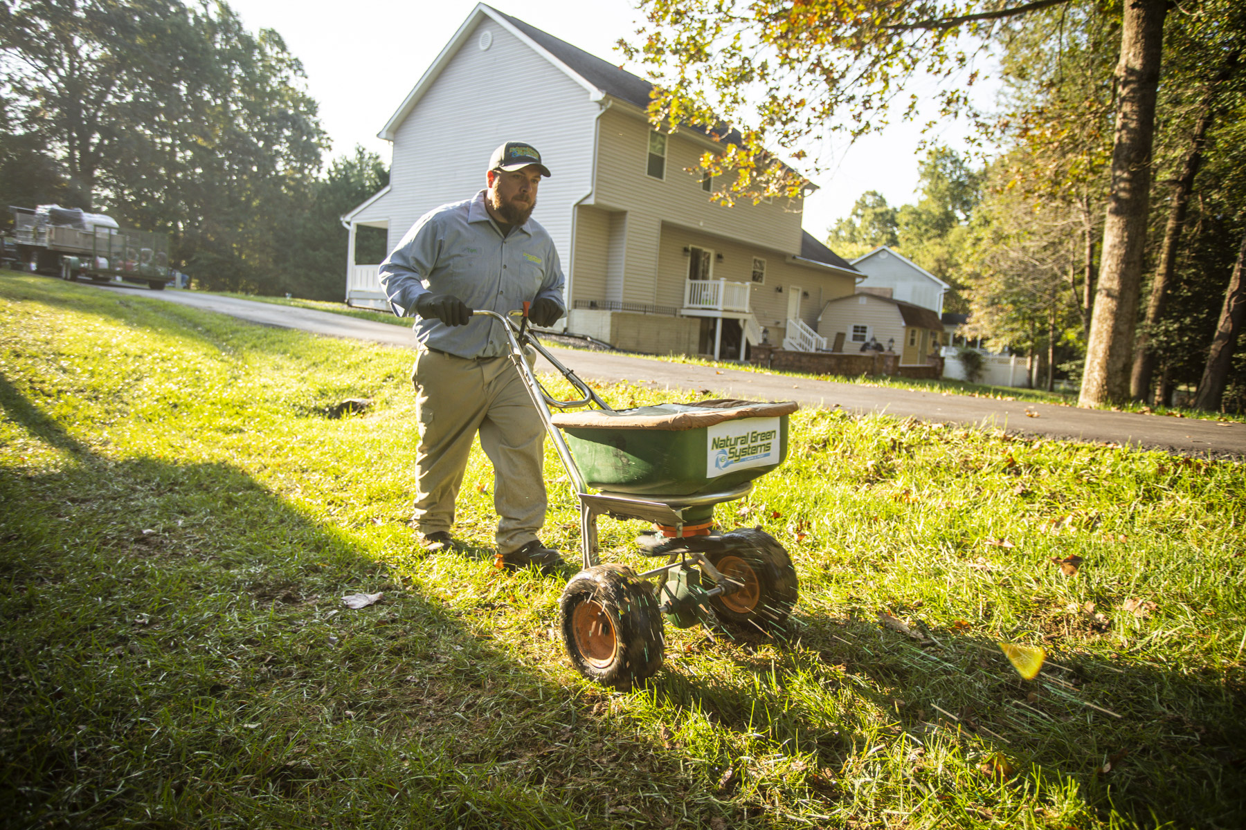 lawn care technician preforms fall lawn maintenance