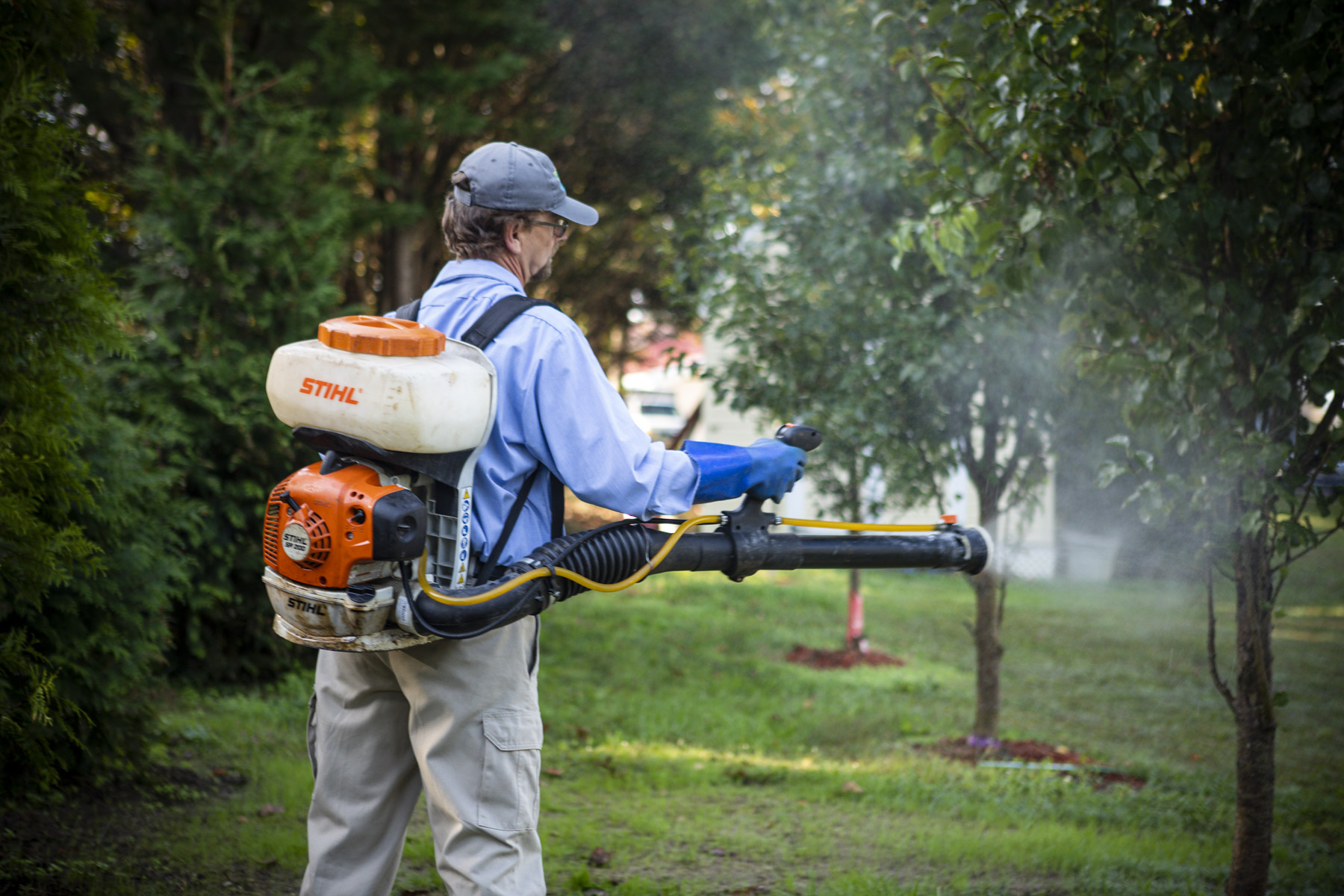 pest control technician spraying for mosquitoes