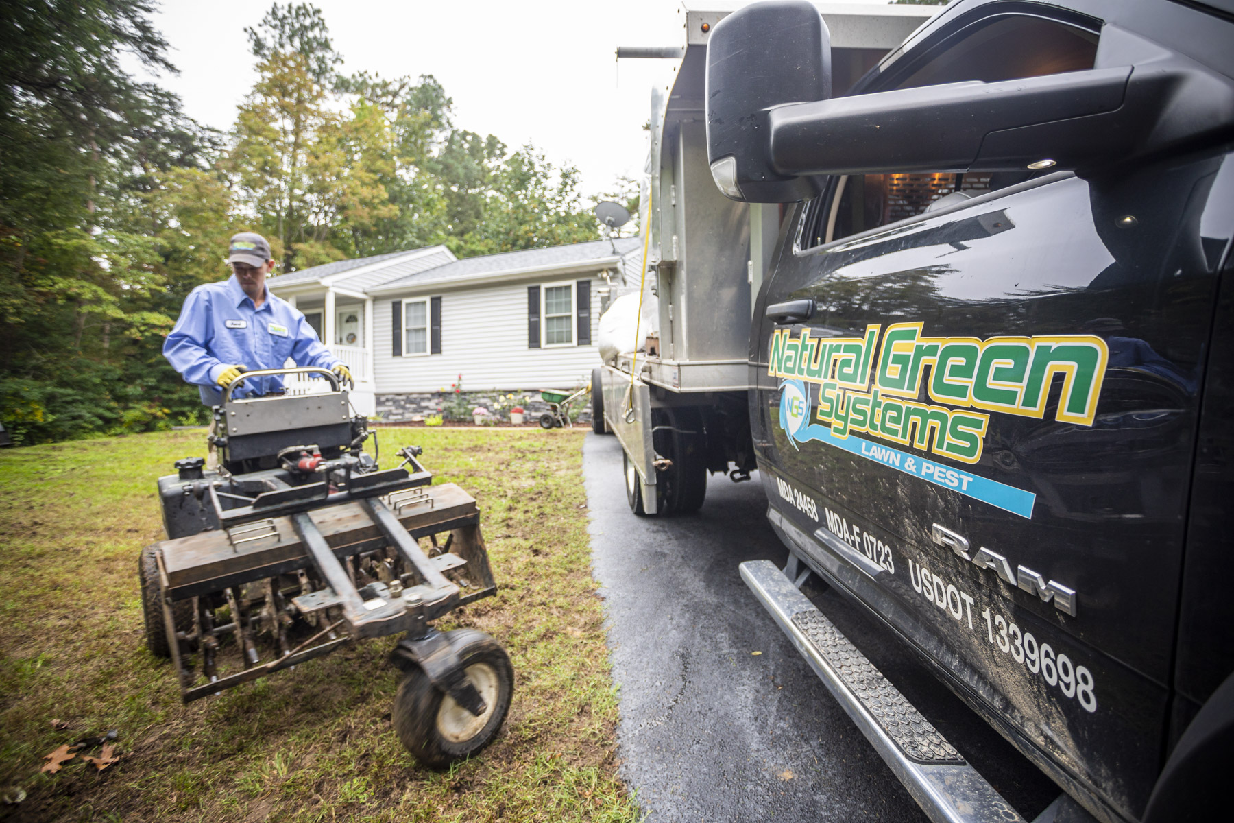 lawn care team unloads aeration machine from truck